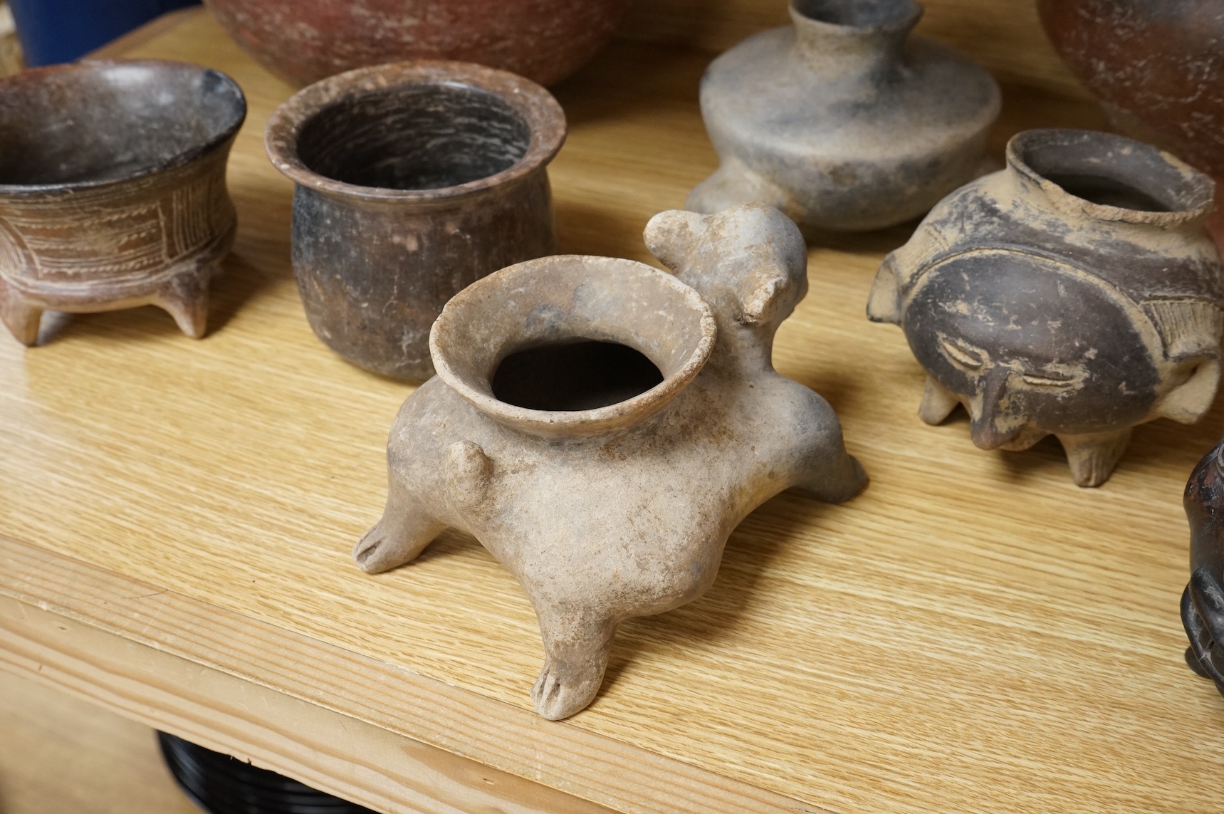 A collection of various South American vessels some in the form of grotesque heads, largest 24cm wide